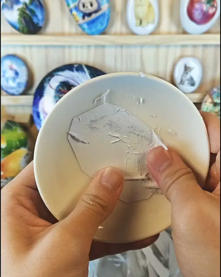 The soaked paper being rubbed away with fingertips